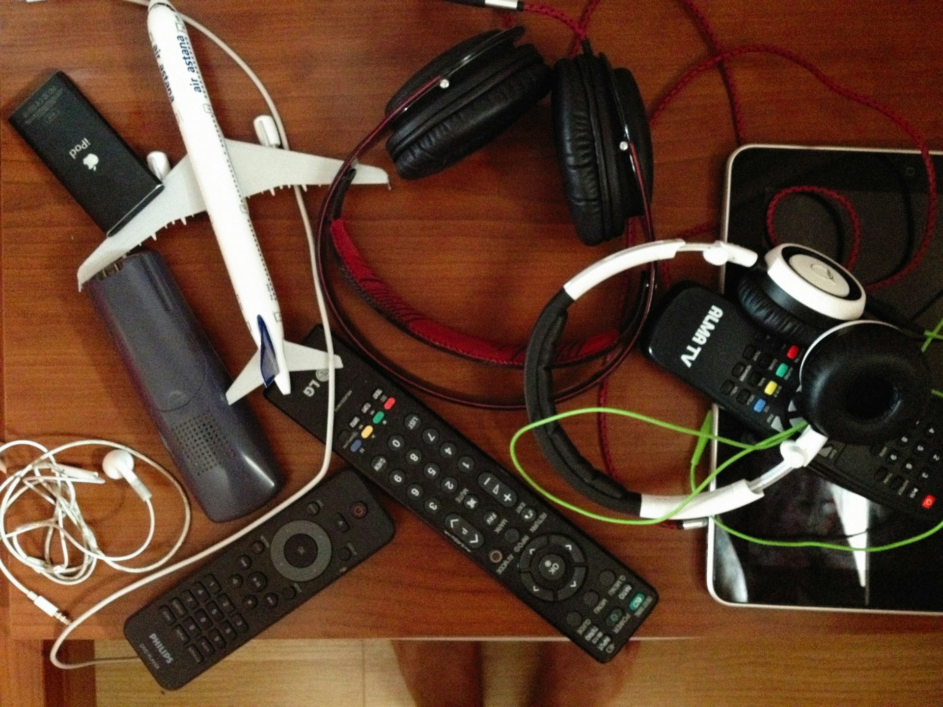 a wooden table topped with electronics and headphones